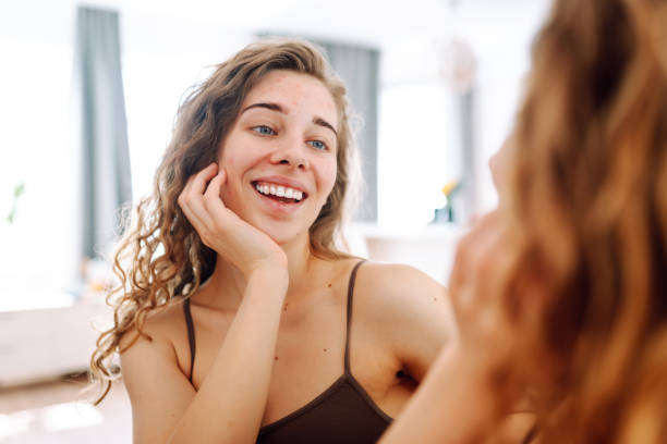 istock Skin Problem. Depressed Woman Touching Pimple On Face Looking At Mirror. 1943286464