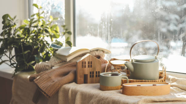 istock Cozy winter photo, stack of sweaters, book, tea and candle 1943332055