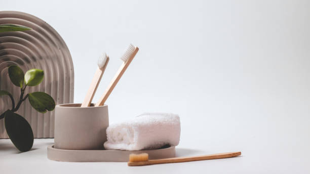 istock Bamboo toothbrushes in a stylish concrete glass on a white background 1943332586