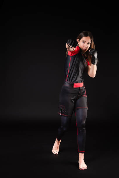 The Caucasian MMA fighter executes a powerful blow, showing her commitment, determination and seriousness in each movement. Her determined approach and serious attitude reflect the intensity she brings to her training and competition, highlighting her unwavering dedication to mixed martial arts.