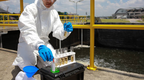 istock Water analysis operator wearing PPE examining  and auditing water from the water treatment plant, industrial and environmental concept 1943363197