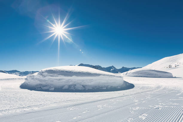 A beautiful snow-covered mountain landscape with bright rays of sunlight breaking through the clouds. A picturesque winter view of snow-capped Alpine peaks. Perfect for travel, tourism, adventure, inspiration, and nature concepts.