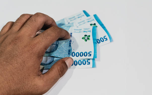 istock Man hand and 50,000 rupiah banknotes. 1943423684
