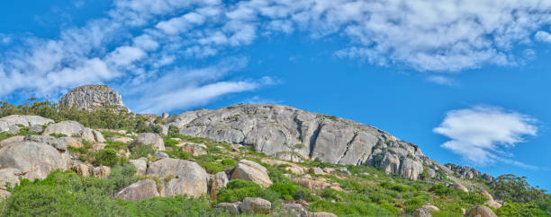 boulders and wilderness - and blue sky with clouds - straggling стоковые фото и изображения