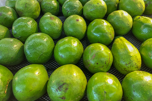 piles of avocados at the market, perfect for a fresh green background