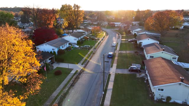 Establishing shot of small town in USA. Colorful autumn fall foliage in neighborhood. Aerial drone shot of homes and houses in United States of America.