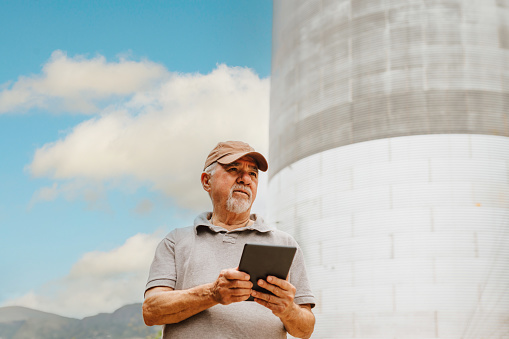 Farmer using tablet next to the agro silo