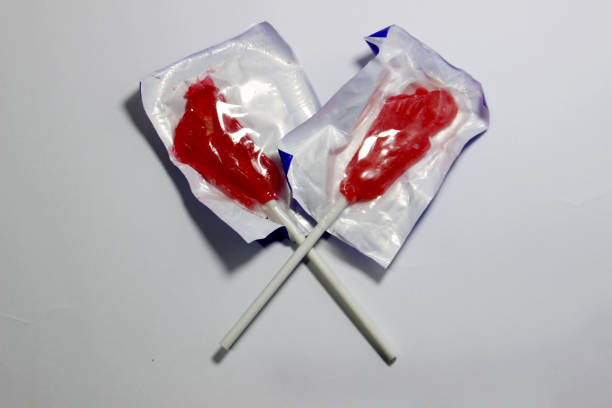 a pair of red candies crossed on white paper