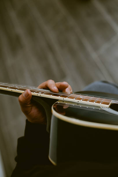 istock unknown person playing an old acoustic guitar. 1943701934