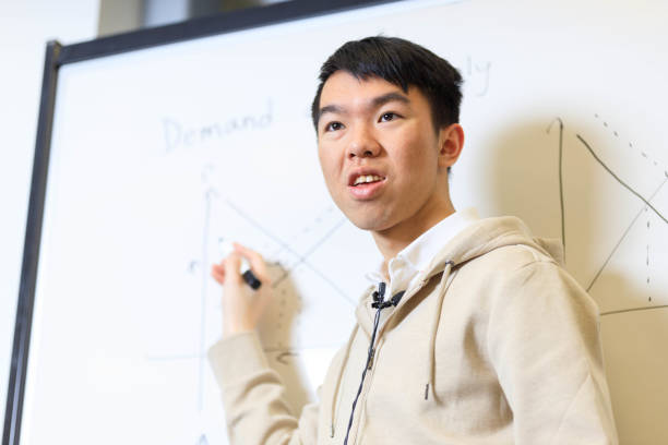 istock Young college student tutoring in front of a whiteboard for a video 1943727476