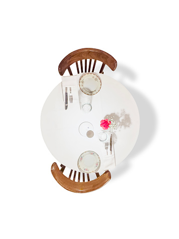Looking down on a restaurant table with empty plates on white background