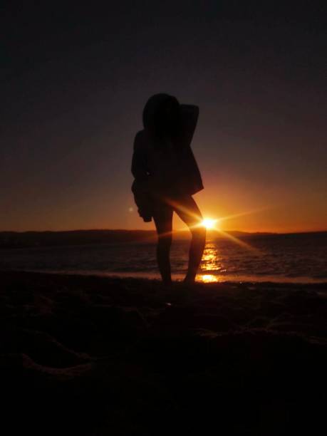 istock Girl in profile at the beach sunset 1943816269
