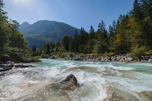 Lush forest surrounds the turquoise waters of Velika Korita SoÄa in the heart of the Slovenian landscape.