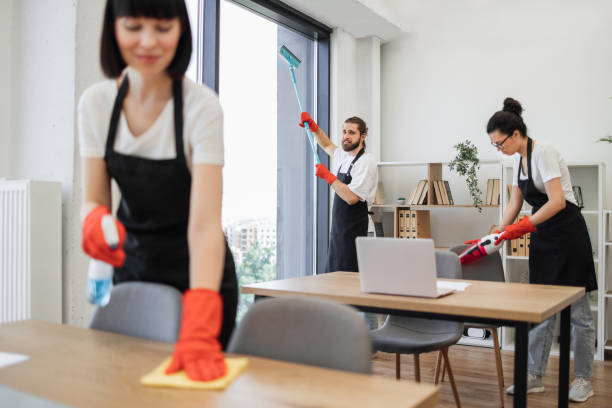 istock Caucasian worker in a black apron cleaning panoramic window. 1943842406