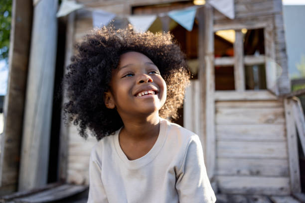 Happy African American girl having fun in a tree house and smiling