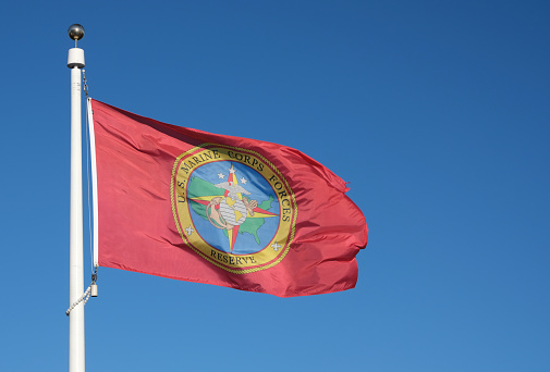 U.S. Marine Corp Forces Reserve flag against a blue sky background