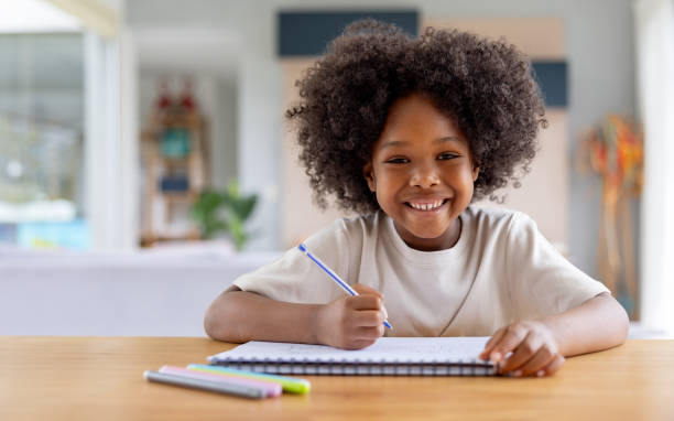 istock Happy girl at home doing her homework 1943859908