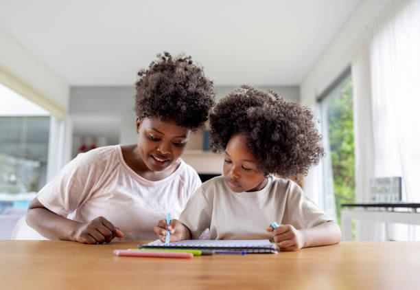 istock Mother helping her daughter doing her homework 1943859912