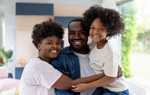 Portrait of a happy African American family smiling at home and looking at the camera - home ownership concepts