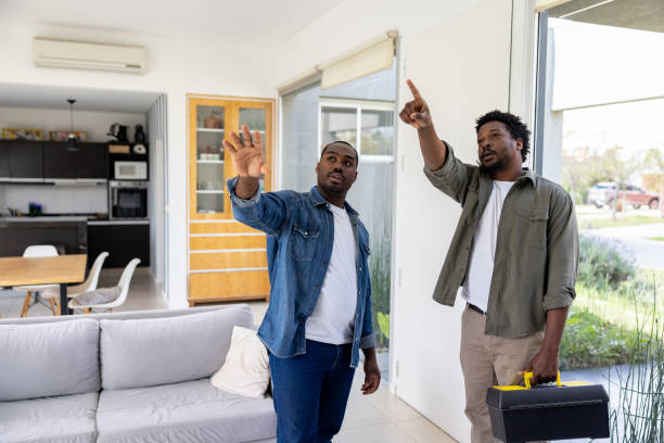 Electrician talking to a man at home about a service
