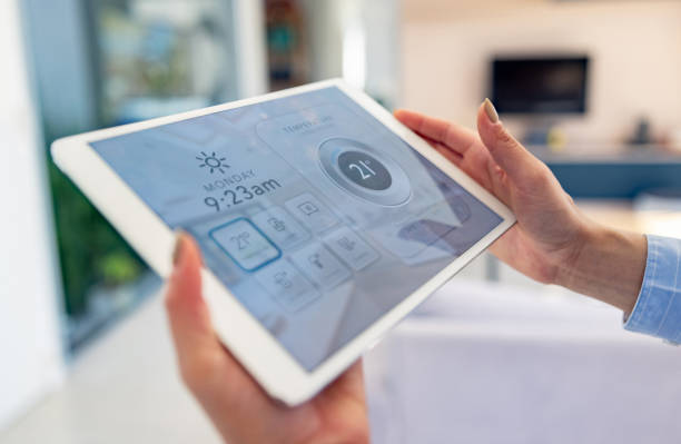 Woman controlling the temperature of smart home using a digital tablet