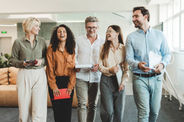 istock Group of positive handsome businesspeople, students, managers walking, working in modern office 1943864709