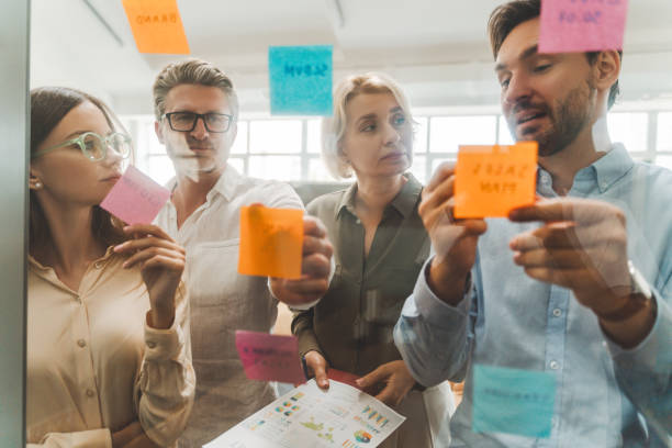 istock Group of serious confident businesspeople using sticky notes, agile methodology for productivity 1943864726