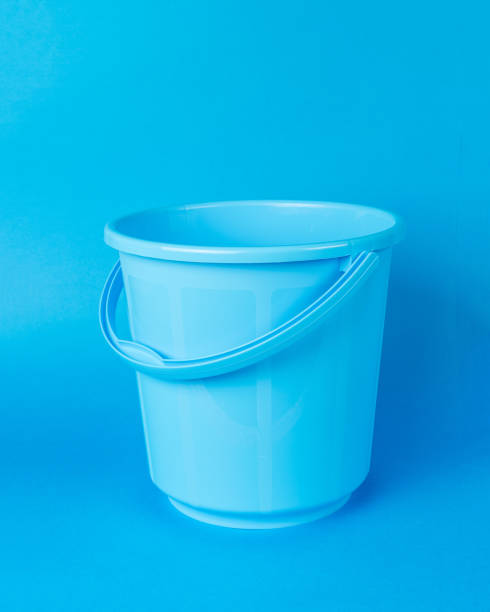 istock A blue bucket with a handle on a blue background. 1943885032