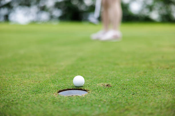 istock woman golfer teeing golf in golf tournament competition at golf course, selective focus on golf ball, 1943890797