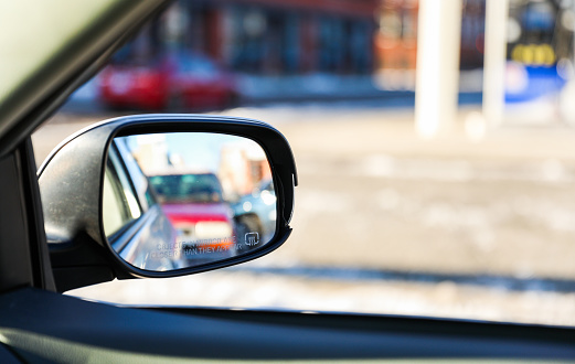 car mirror reflecting past, present, and future, symbolizing the journey of life and the pursuit of dreams