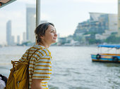 Woman traveling by boat on Chao Phraya river In Bangkok