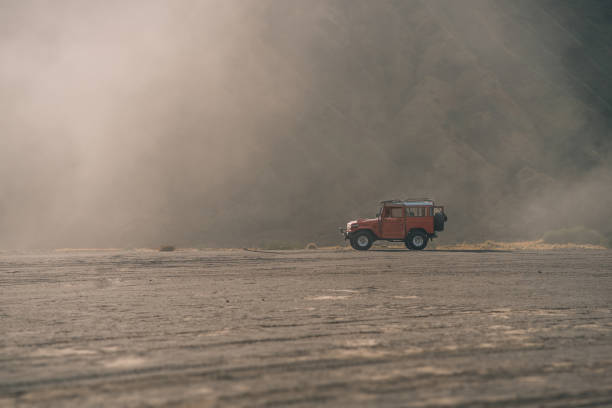 istock Offroad red offroad SUV at misty Bromo mountain 1944005850