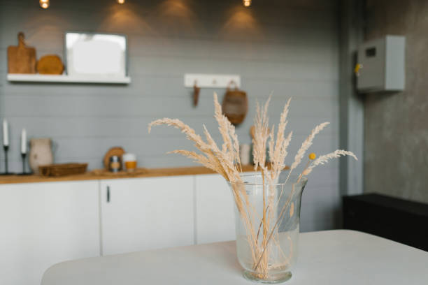 istock Dry grass branches in a glass vase on the table in the Scandinavian kitchen 1944012062