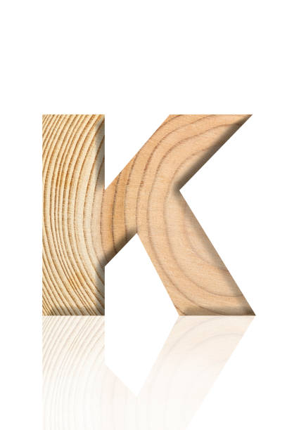 Close-up of three-dimensional tree ring alphabet letter K on white background.