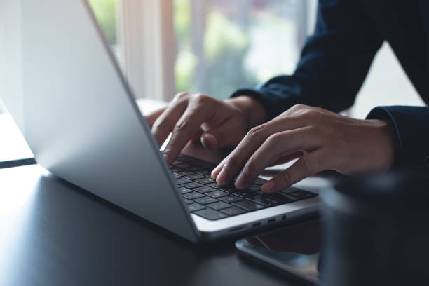 istock Business man hands typing on laptop computer keyboard, searching information, surfing the internet on dark office desk, distance job, online working, business and technology concept 1944118509