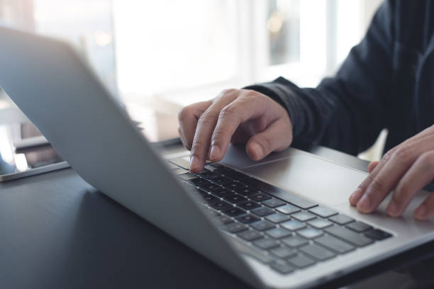 istock Business man hands typing on laptop computer keyboard and surfing the internet on office table, online working, business and technology, internet network communication concept, close up 1944128193