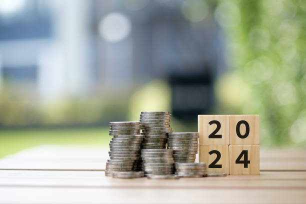 Wooden blocks number 2024 and stack of coins.