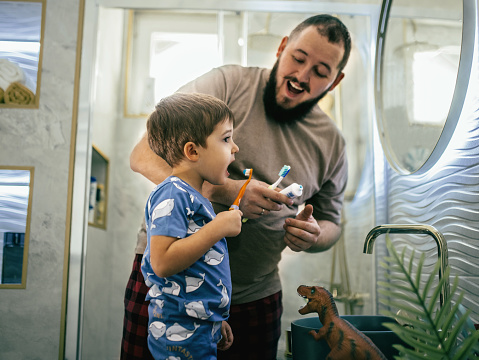 dad and son go to the bathroom to brush their teeth, perform their morning routines