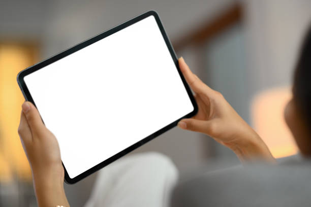istock Closeup woman using digital tablet while lying on couch at home 1944197394