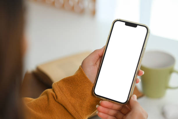 istock Closeup woman in yellow sweater using mobile phone at home. Empty screen for application advertising 1944197960
