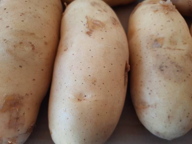 istock Organic fresh potatoes on a brown background, close-up view 1944207046