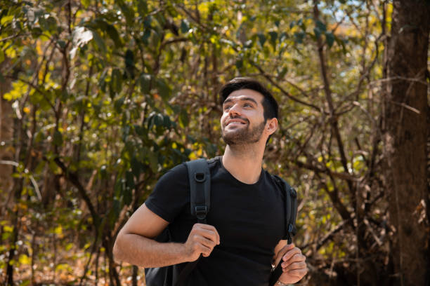 istock Happy Caucasian man carrying backpack traveling spends free time hiking, walking, exploring, adventure in forest beautiful autumn day, enjoying nature amidst mountains and trees during the weekend. 1944208193