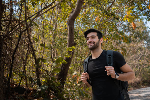 istock Happy Caucasian man carrying backpack traveling spends free time hiking, walking, exploring, adventure in forest beautiful autumn day, enjoying nature amidst mountains and trees during the weekend. 1944211340