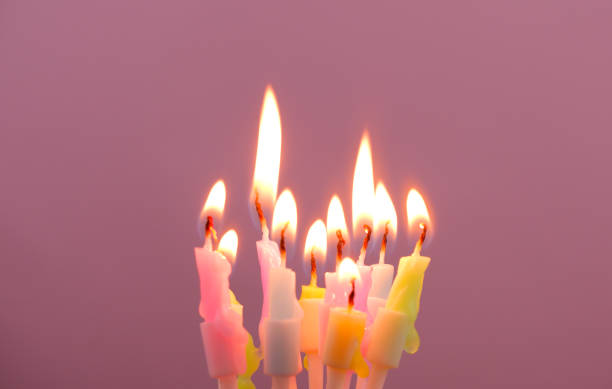 istock Birthday candles burning on pink background, copy space for text. 1944256768