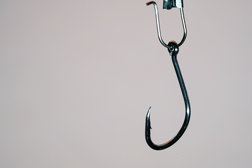 Fishing hook on a background of blue and white bokeh