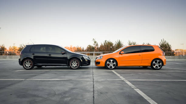 side view of two volkswagen hatchbacks - hatchback volkswagen golf volkswagen side view imagens e fotografias de stock