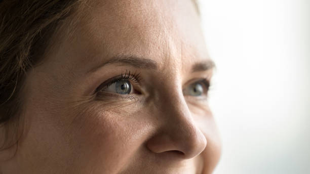 Blue eyes of young middle aged woman looking away stock photo