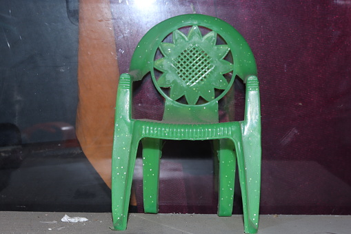 A small green weak Indian plastic Chair toy