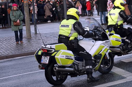 2 danish policeofficers fully equipped on policemotorbikes at a crossroad in front of the danish Government Building of Christiansborg on a sunny day in Copenhagen, Denmark
