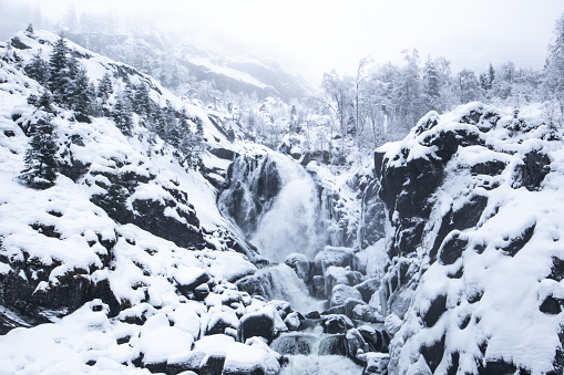 Capture of an impressive waterfall in Hardanger, Norway in winter with snow